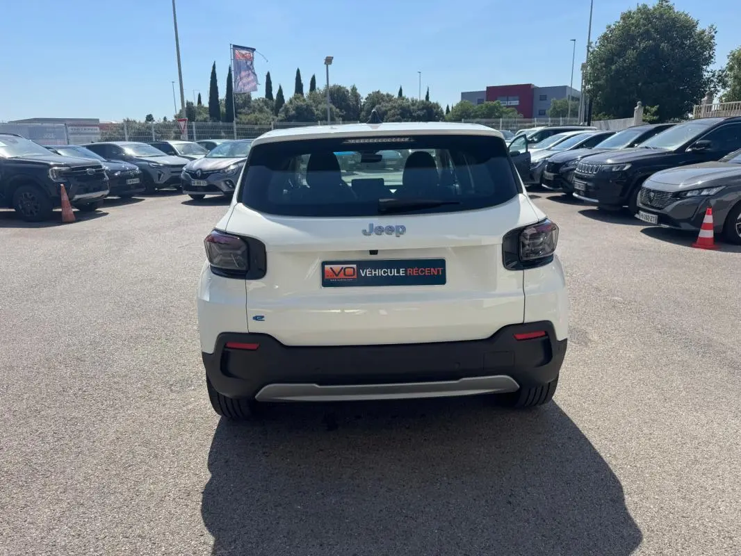 Vue arrière d'un Jeep Avenger électrique blanc 2025 avec feux arrière fumés et plaque d'immatriculation "Véhicule récent".