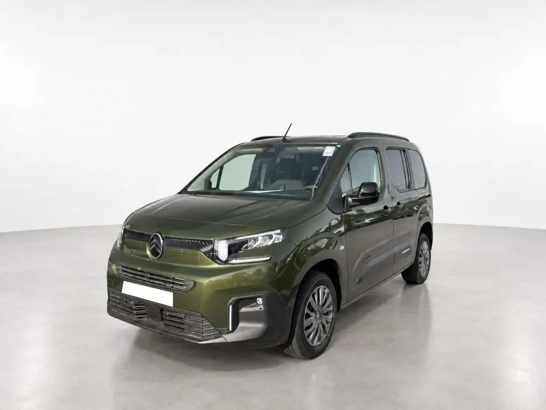 Citroën Berlingo Sirkka green en 3/4 avant droit, avec barres de toit et vitres surteintées visibles.