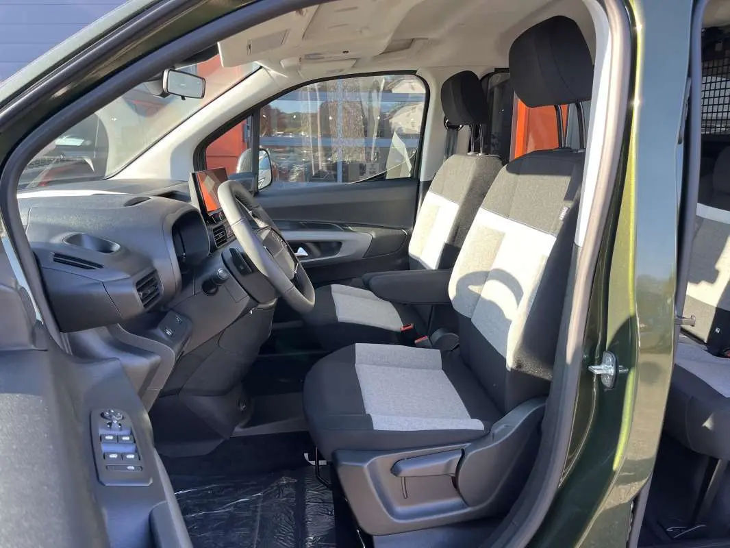 Vue intérieure côté conducteur du Citroën Berlingo 2026 Sirkka green, montrant les sièges tissu bicolores et le volant multifonctions.