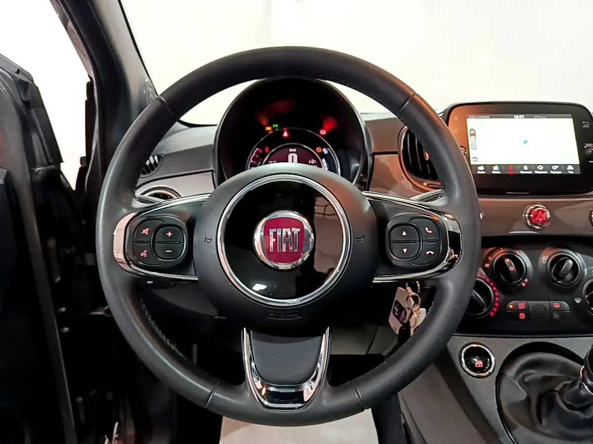 Vue centrée sur le volant cuir noir de la Fiat 500 2022 avec tableau de bord et écran tactile visible.