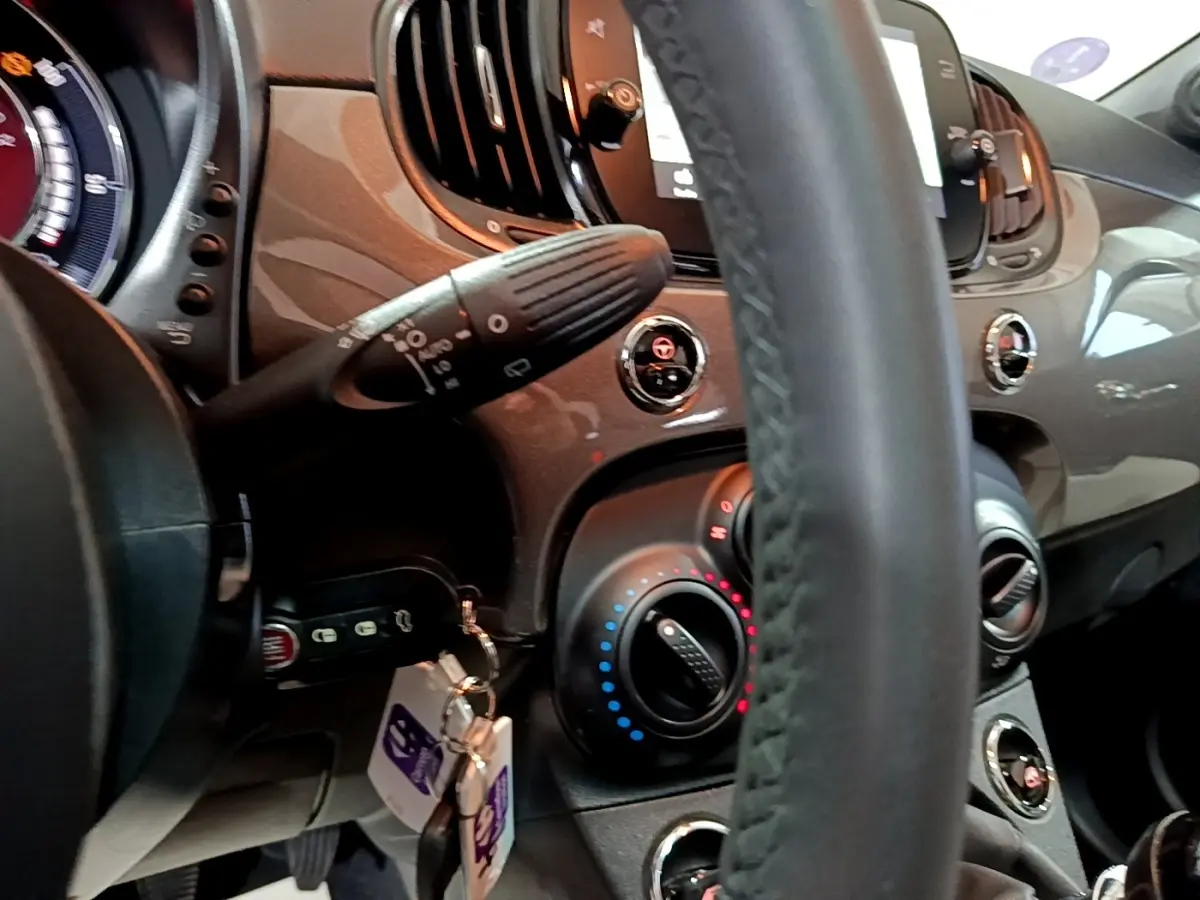 Vue rapprochée de l’intérieur gris foncé du tableau de bord et volant cuir de la Fiat 500 1.0 Dolcevita 2022.