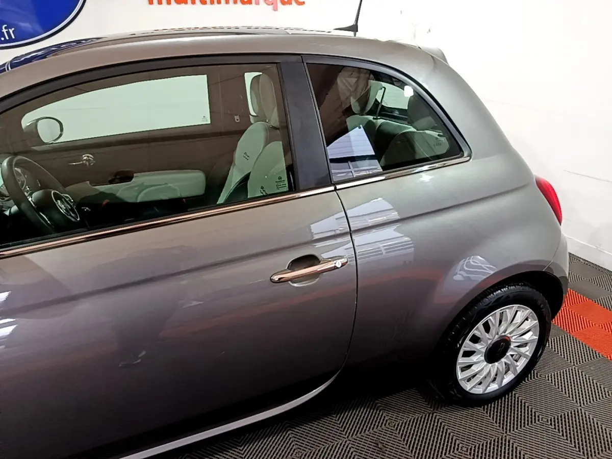 Vue latérale droite d'une FIAT 500 gris foncé 2022, mettant en valeur la porte et la jante design.