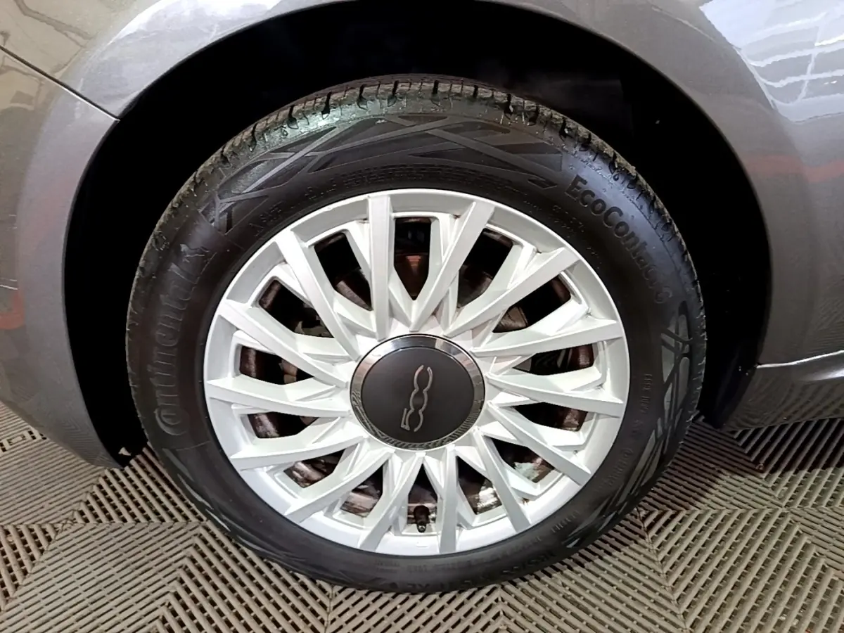 Gros plan sur la roue avant droite gris foncé d'une FIAT 500 1.0 70ch BSG Dolcevita avec jante argentée stylisée.