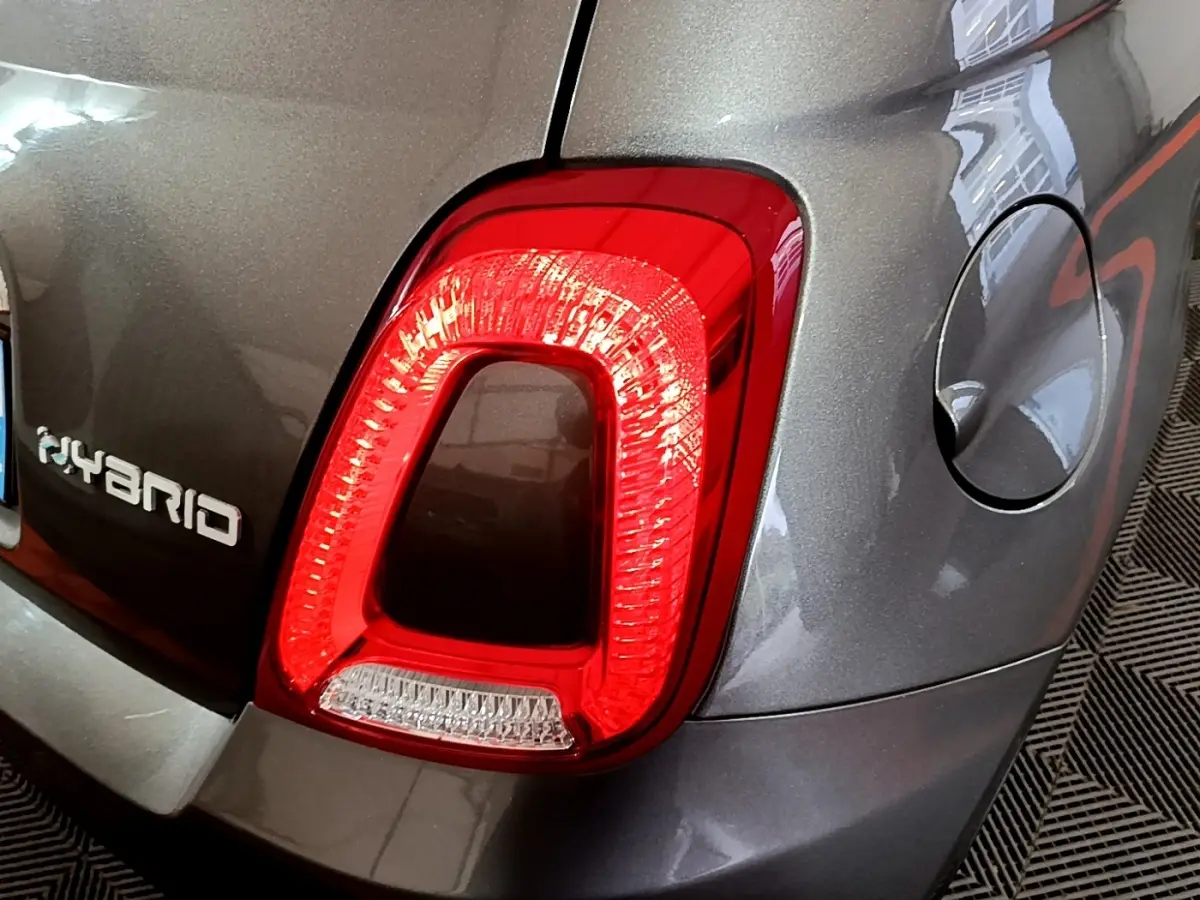 Gros plan sur le feu arrière droit rouge d'une FIAT 500 hybride gris foncé avec logo Hybrid visible sur le coffre.