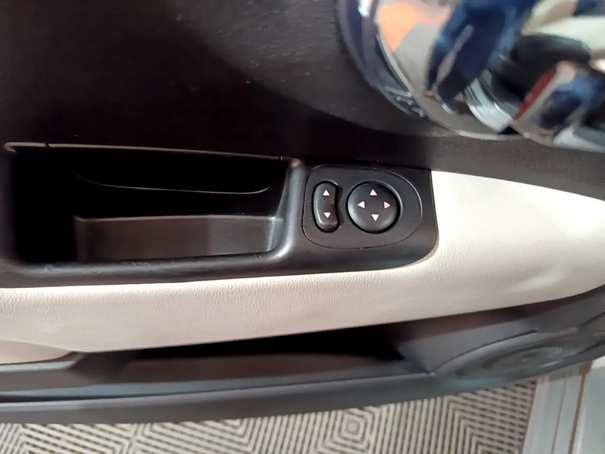 Détail des commandes de réglage des rétroviseurs sur la portière côté conducteur de la Fiat 500 gris foncé.