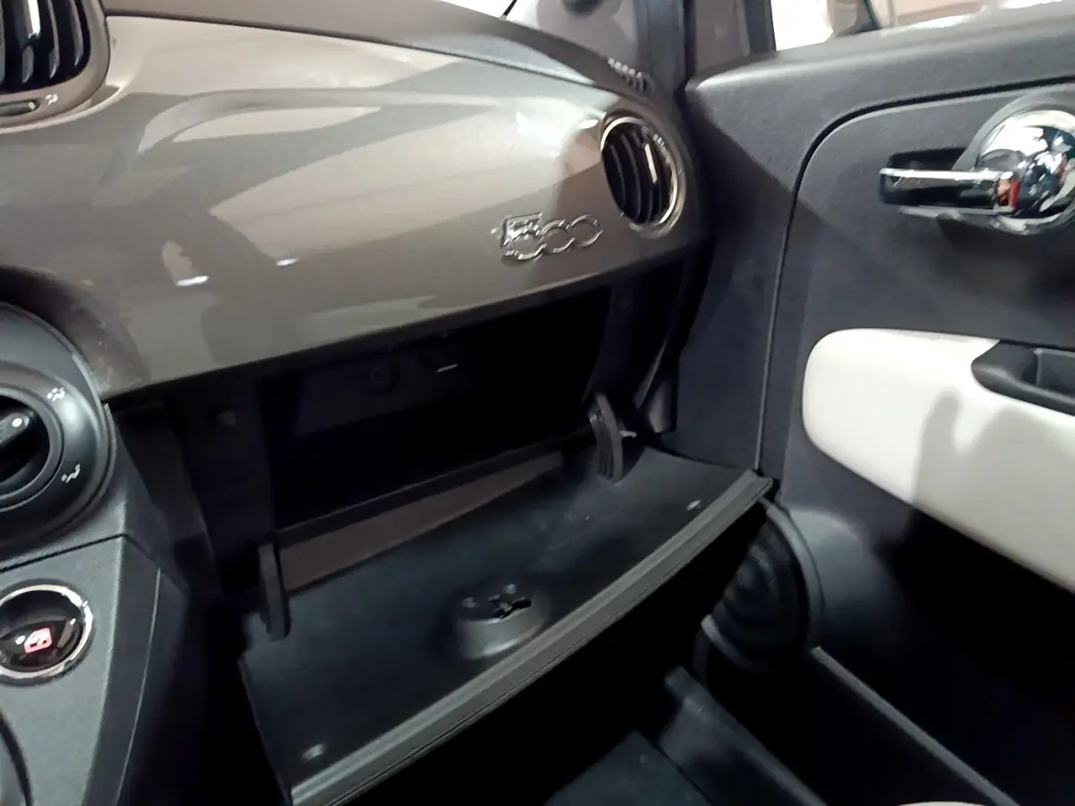 Vue intérieure côté passager du tableau de bord gris foncé avec boîte à gants ouverte et logo 500 visible.