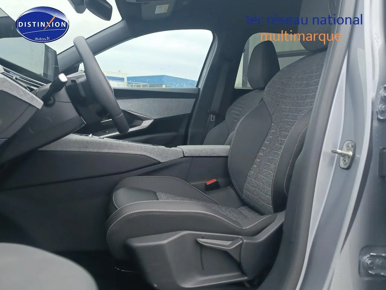 Vue intérieure côté conducteur du Peugeot 5008 Hybrid 145 allure gris artense, mettant en valeur le siège en tissu et cuir.