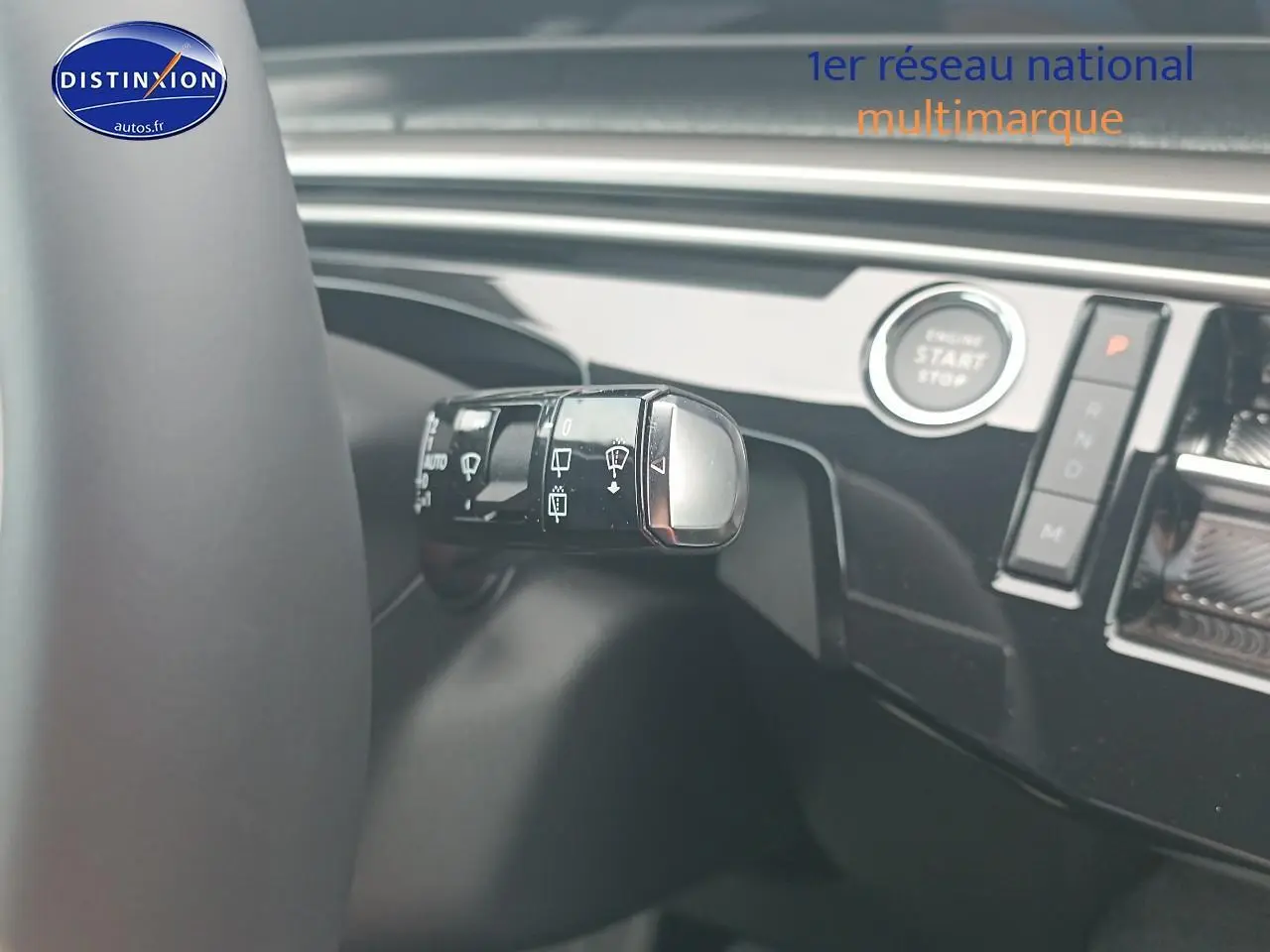 Gros plan sur la commande des essuie-glaces et le bouton start/stop du Peugeot 5008 gris Artense, intérieur moderne.