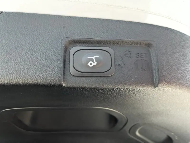 Bouton de commande de hayon électrique sur intérieur noir du coffre d’un Ford Puma blanc 2025.