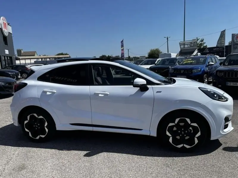Ford Puma blanc en vue de profil côté gauche, avec jantes au design géométrique et vitres teintées.