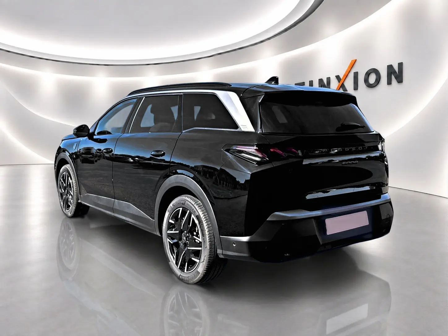 Peugeot 5008 Hybrid 145 GT noir en 3/4 arrière droit, avec jantes alliage et toit noir brillant dans un showroom lumineux.