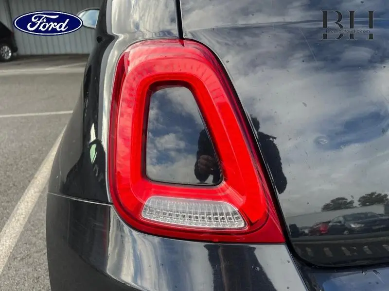 Gros plan sur le feu arrière gauche rouge d'une FIAT 500 noire, soulignant la finition Rosso Amore.