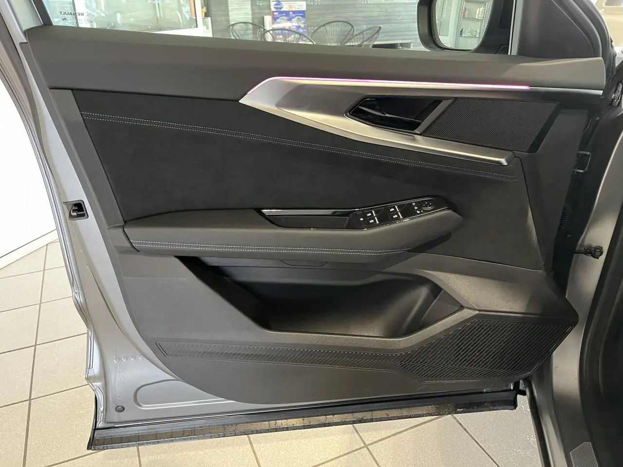 Intérieur de la porte avant gauche du Renault Austral 2025 gris, avec éclairage d’ambiance violet et finitions Alcantara.