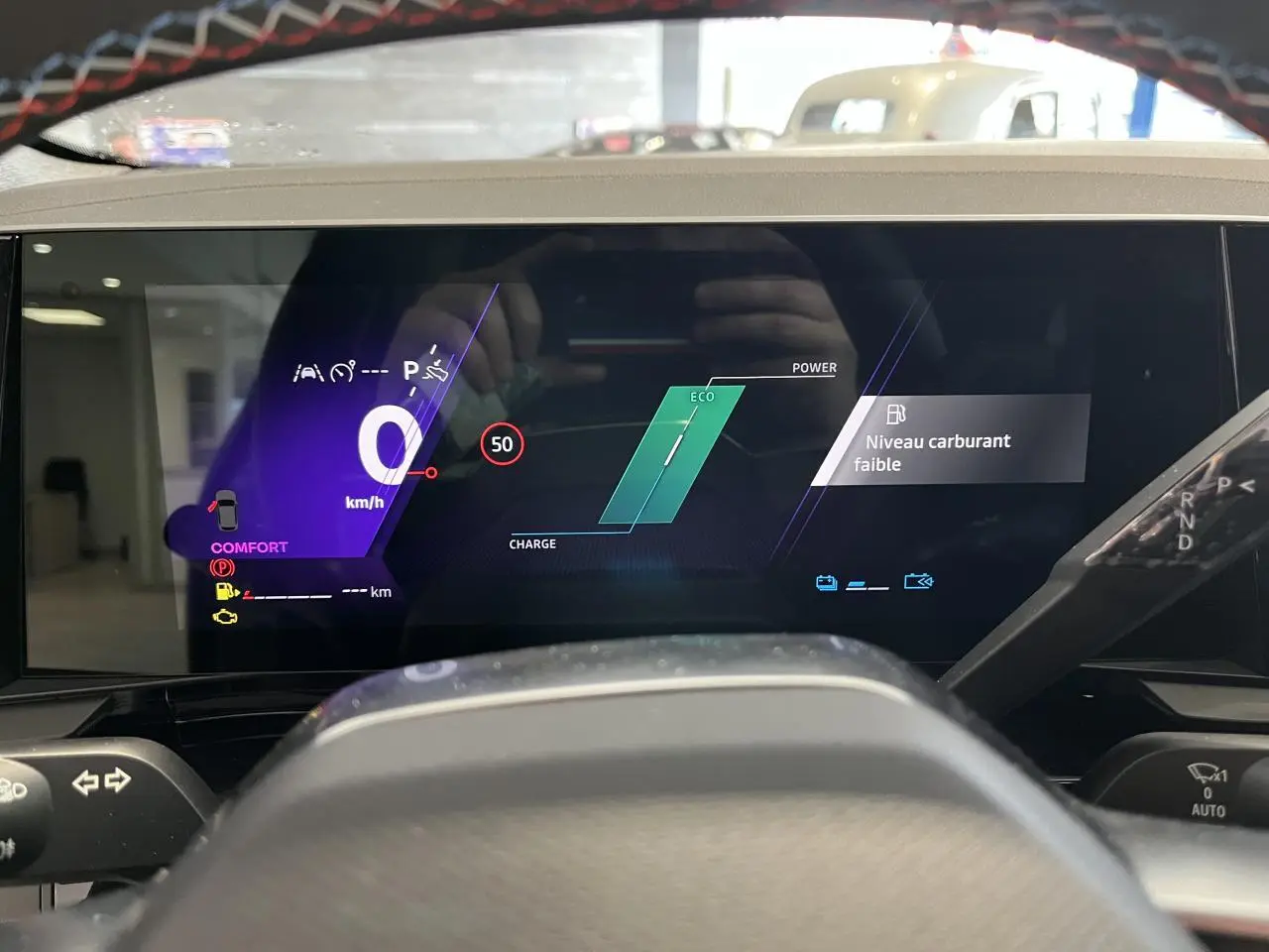 Tableau de bord numérique du Renault Austral 2025 affichant vitesse, mode Eco et alerte niveau carburant faible.