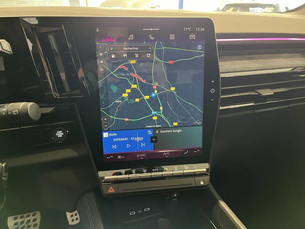 Vue rapprochée de la console centrale du Renault Austral 2025, écran tactile avec navigation et commandes climatisation.