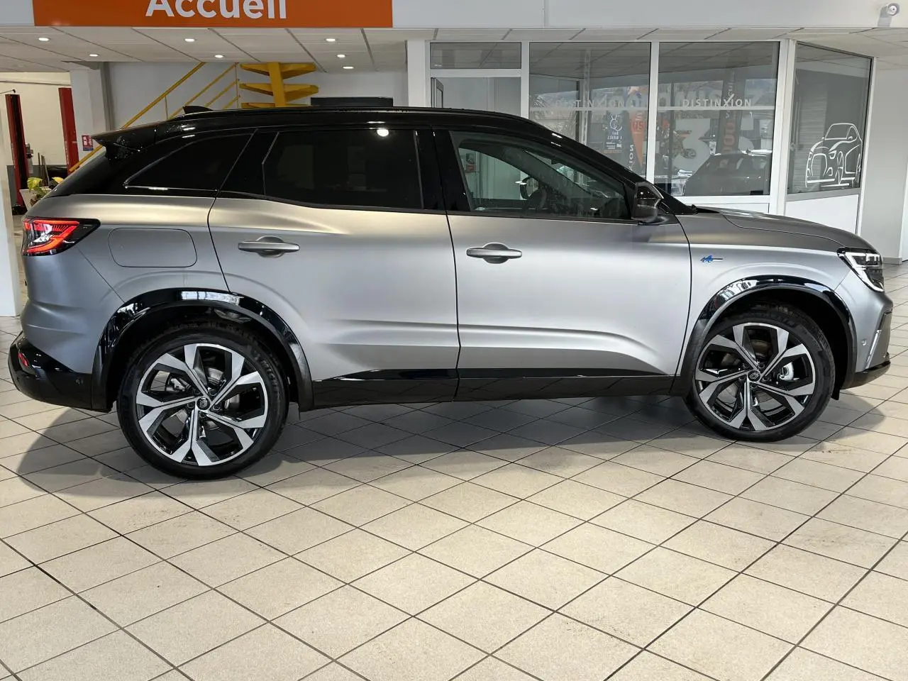 Vue de profil côté gauche d'un Renault Austral gris avec toit noir étoilé et jantes alliage 20 pouces diamantées.