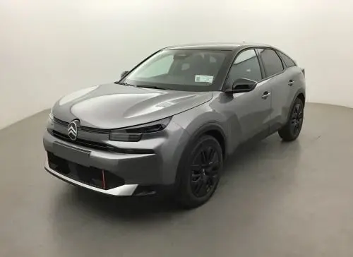 Vue 3/4 avant d'une Citroën C4 hybride 2025 gris Mercury avec jantes noires et signature lumineuse LED distinctive.