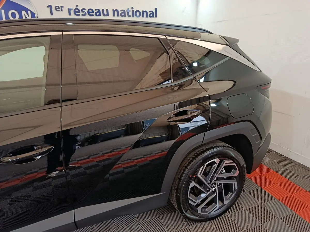 Vue côté droit arrière du Hyundai Tucson noir 2025 avec jantes alliage et lignes anguleuses marquées.