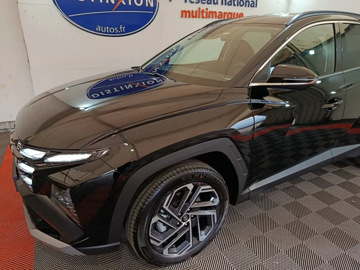 Vue 3/4 avant droite d’un Hyundai Tucson noir 2025 avec jantes alliage et feux LED distinctifs.