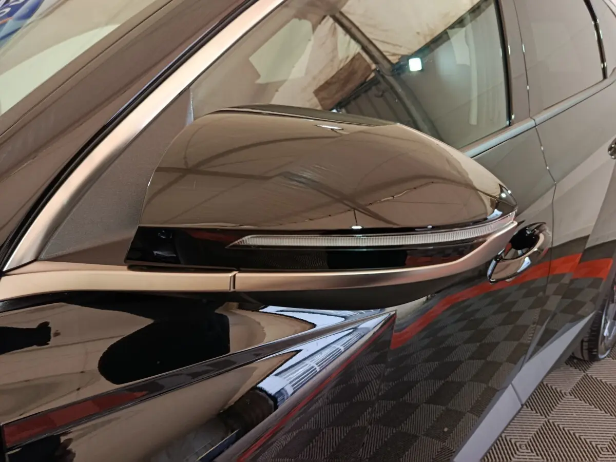 Gros plan sur le rétroviseur droit noir brillant du Hyundai Tucson 1.6 Hybrid 239 Creative Auto 2025.