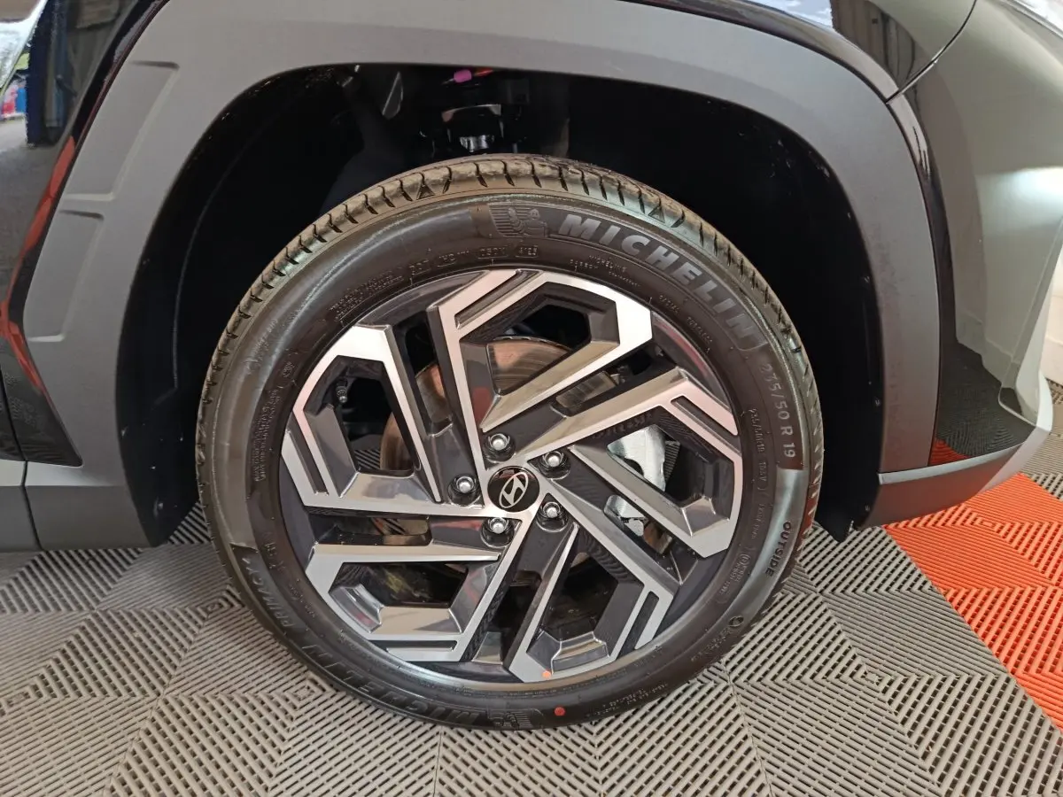 Gros plan sur la roue avant gauche noire du Hyundai Tucson 2025 avec jante alliage et pneu Michelin.
