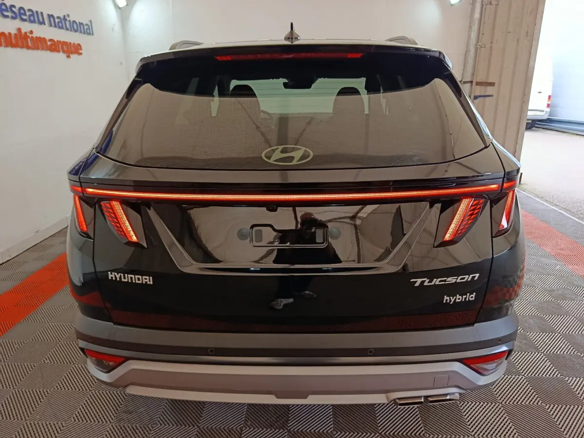 Vue arrière du Hyundai Tucson 1.6 Hybrid noir 2025 avec feux LED distinctifs et logo Hyundai visible.