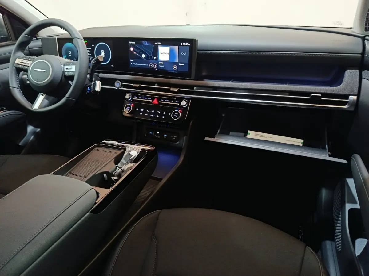 Intérieur noir du Hyundai Tucson 1.6 Hybrid 2025, vue de l'avant droit sur tableau de bord et écran tactile 12,3 pouces.