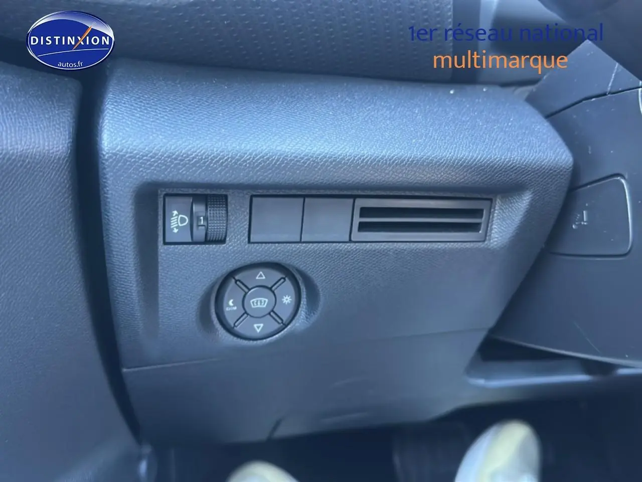 Détail intérieur côté gauche avec commandes d’éclairage et ventilation sur Citroën C4 noire 2025 hybride.