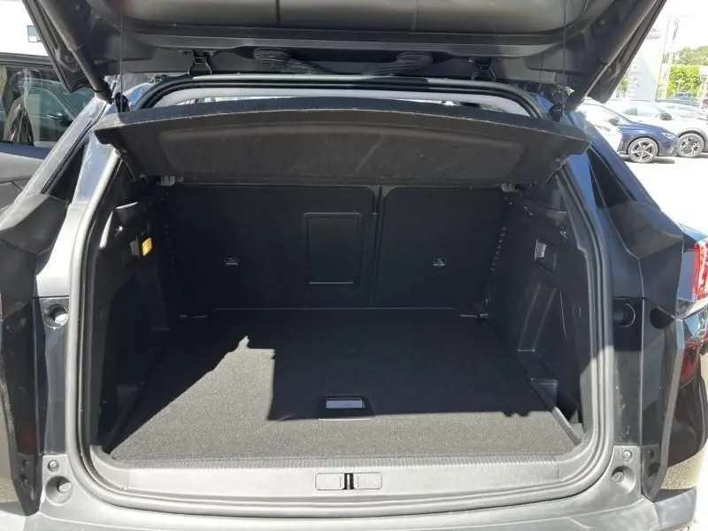 Coffre ouvert vu de l'arrière d'un Peugeot 3008 noir 2021, montrant un espace de chargement spacieux et propre.