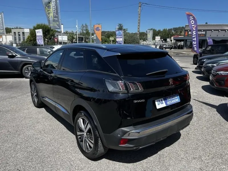 Vue 3/4 arrière droite d’un Peugeot 3008 noir de 2021, avec feux arrière à effet griffes et jantes alliage visibles.