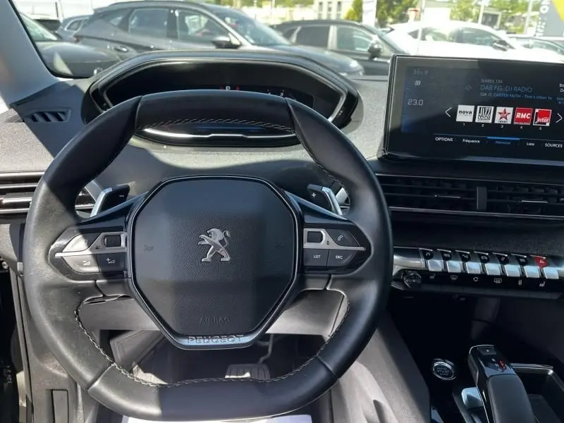 Vue intérieure centrée sur le volant noir du Peugeot 3008 2021 avec tableau de bord digital et écran tactile.