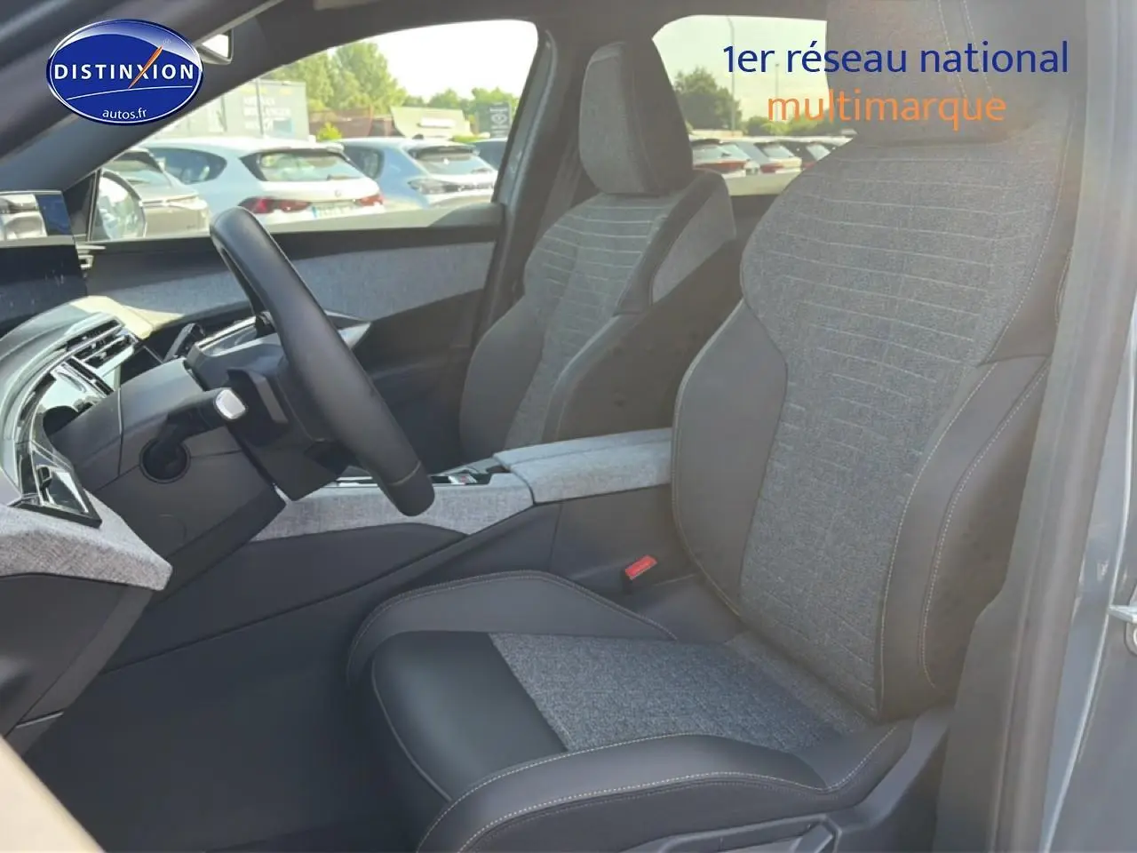 Vue intérieure côté conducteur du Peugeot 3008 bleu 2025, sièges tissu et cuir avec accoudoir central gris.
