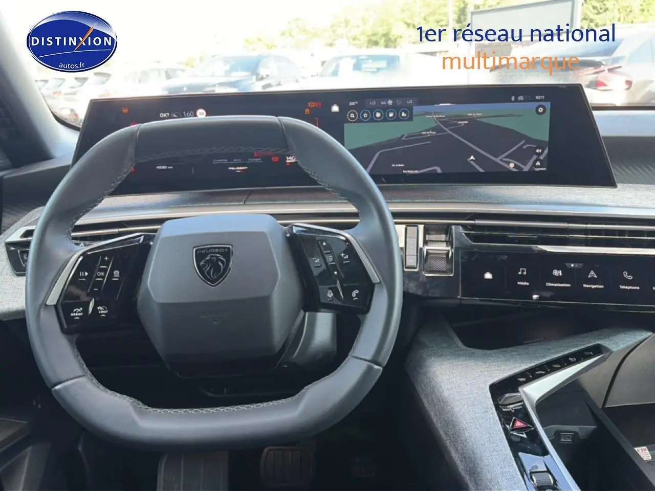 Vue intérieure du tableau de bord de la Peugeot 3008 hybride 2025, volant cuir multifonction et écran tactile large.