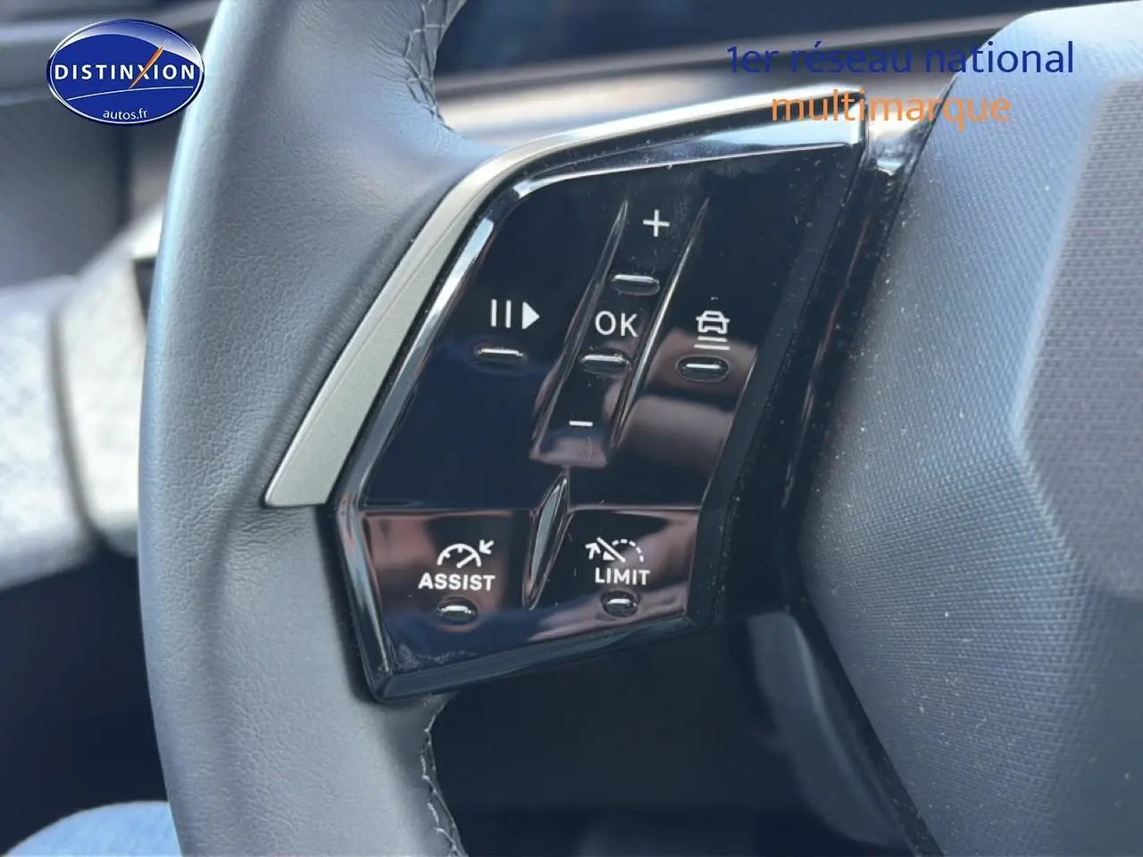 Gros plan sur les commandes multifonctions noires du volant cuir du Peugeot 3008 bleu 2025.