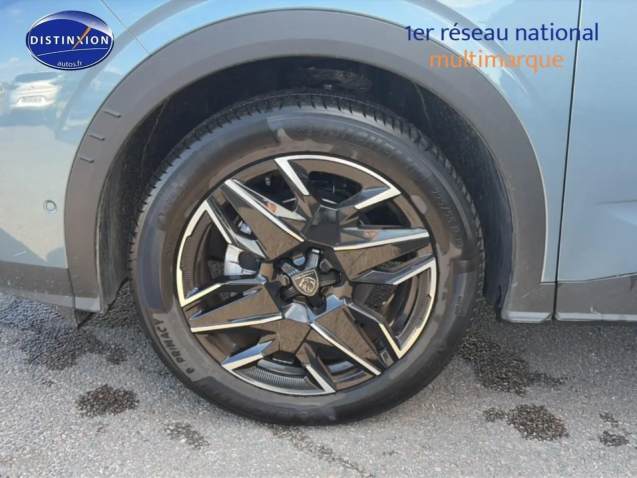Gros plan sur la roue arrière droite d’un Peugeot 3008 bleu 2025 avec jante alu noire et argentée design.