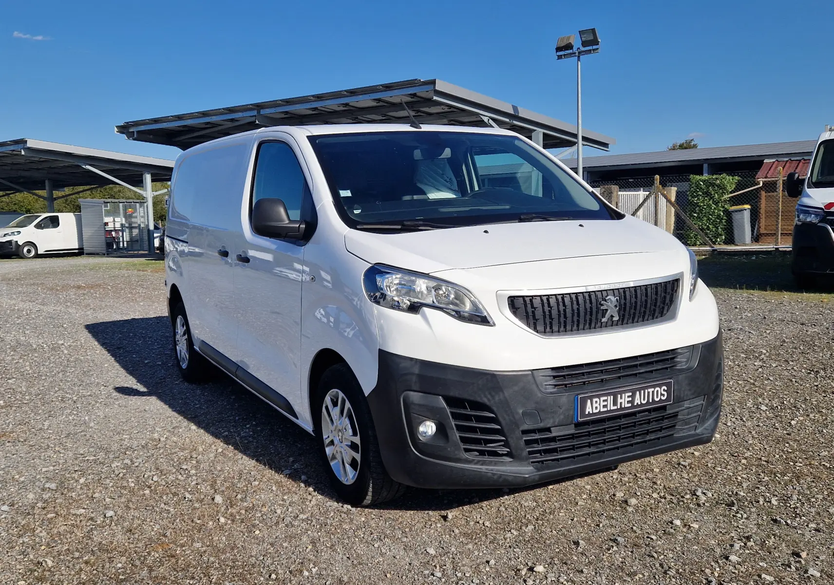 Peugeot Expert Fourgon blanc en 3/4 avant droit, avec calandre noire et plaque Abeilhe Autos visible.
