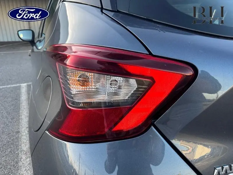 Gros plan sur le feu arrière droit gris acier d'une Nissan Micra 2018 avec becquet et carrosserie lisse.