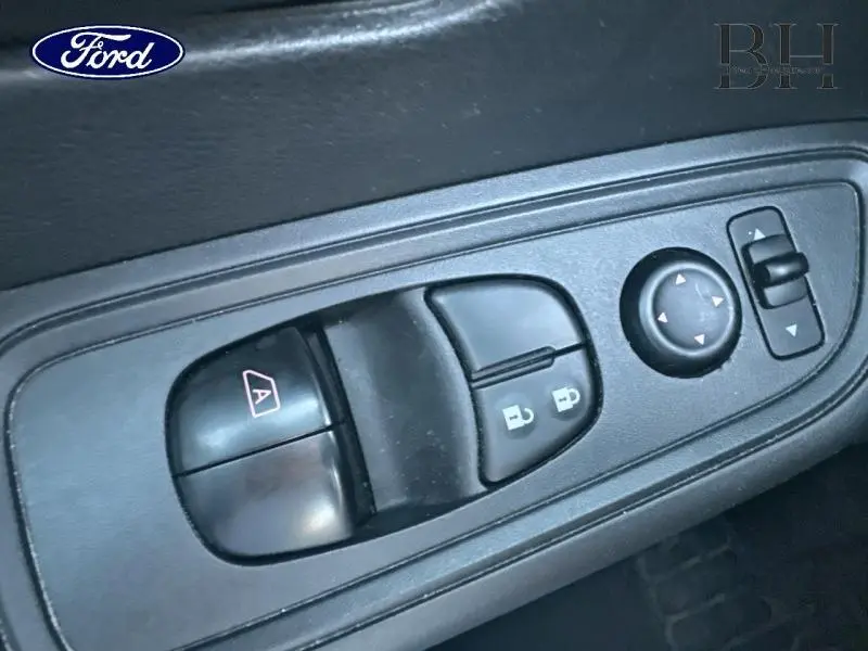 Gros plan sur les commandes de lève-vitres et rétroviseurs électriques côté conducteur d'une Nissan Micra gris acier 2018