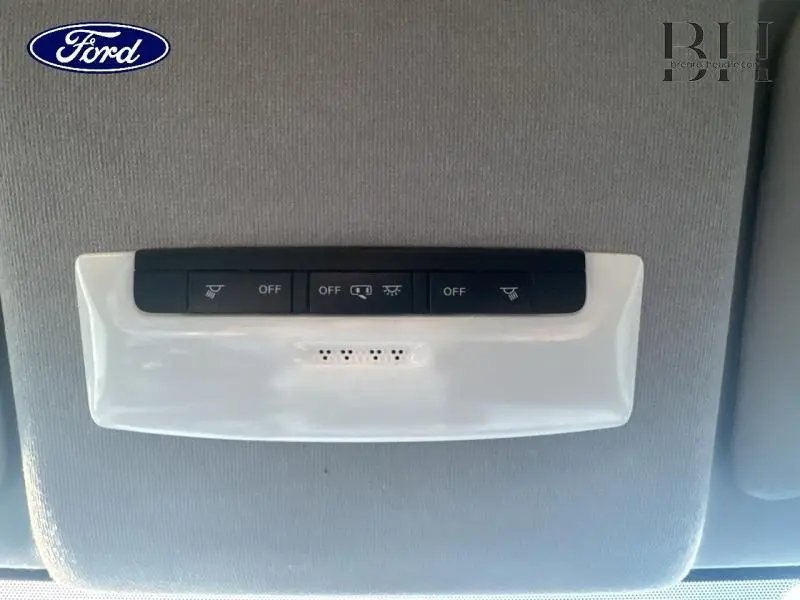 Gros plan sur les commandes de plafonnier noir et blanc dans l'habitacle d'une Nissan Micra gris acier 2018.