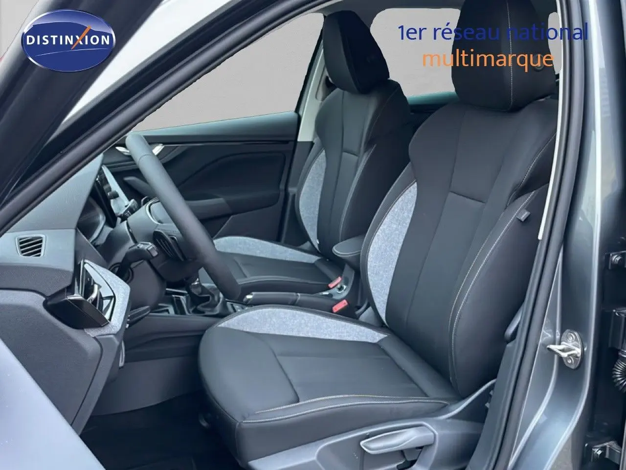 Vue intérieure côté conducteur du Skoda Kamiq 2025 gris graphite, sièges tissu et cuir bicolores avec surpiqûres contrastées.