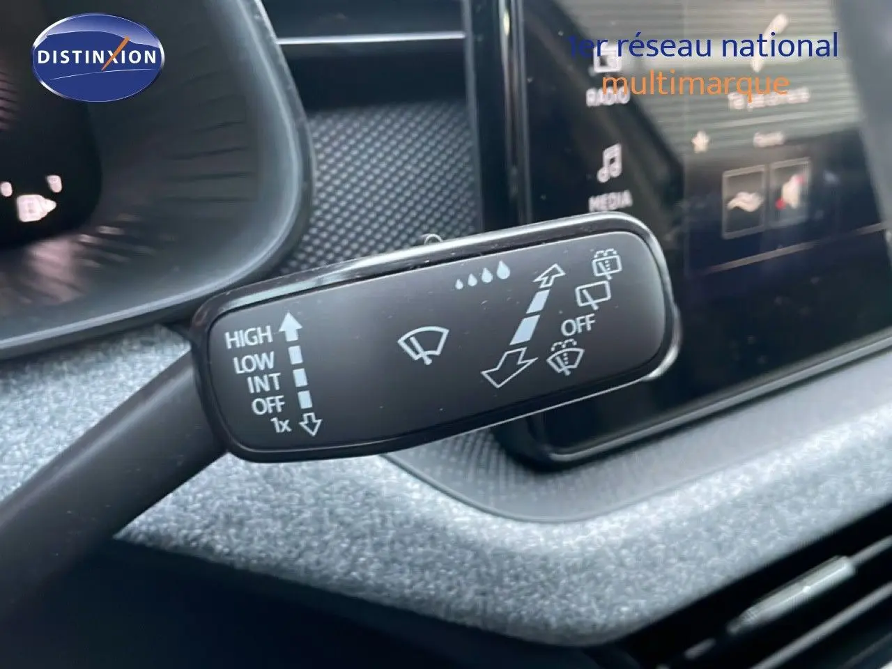 Gros plan sur la commande d’essuie-glace du Skoda Kamiq 2025, intérieur gris graphite avec écran tactile en arrière-plan.