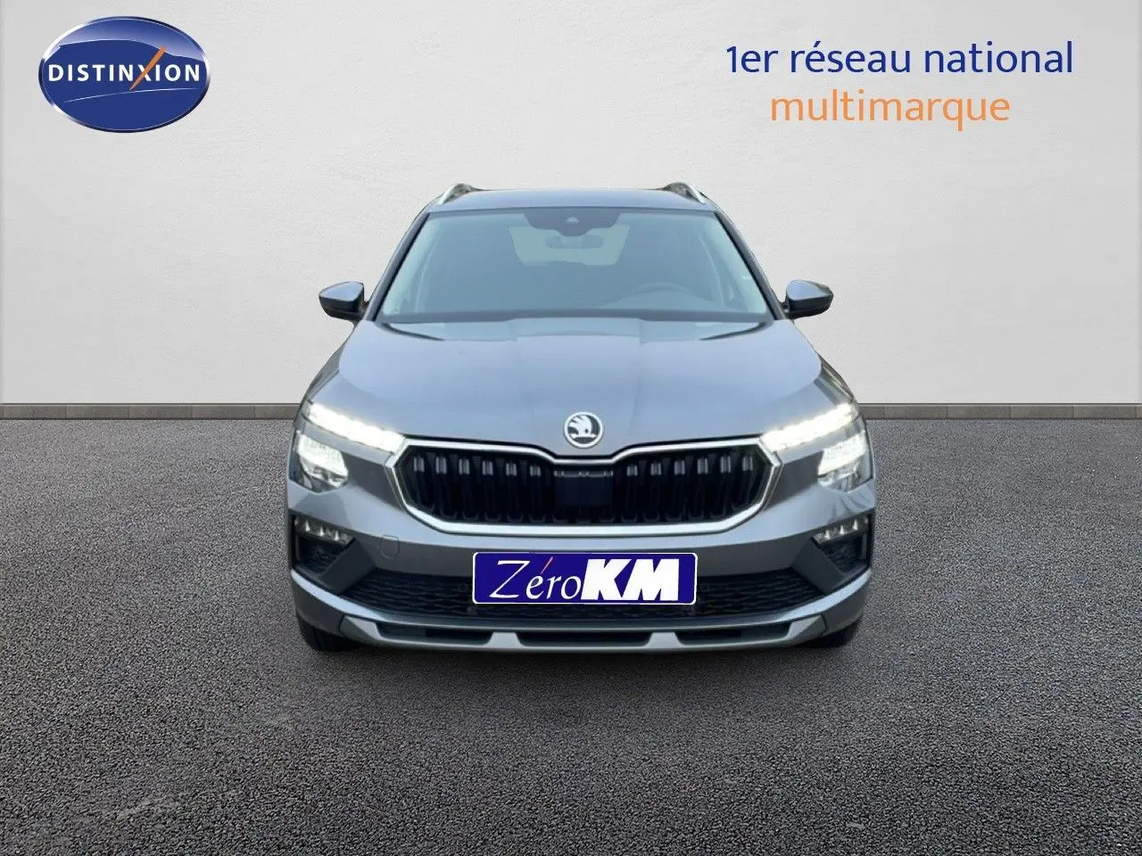 Vue frontale d'un Skoda Kamiq 2025 gris graphite métal avec calandre noire et feux LED allumés.