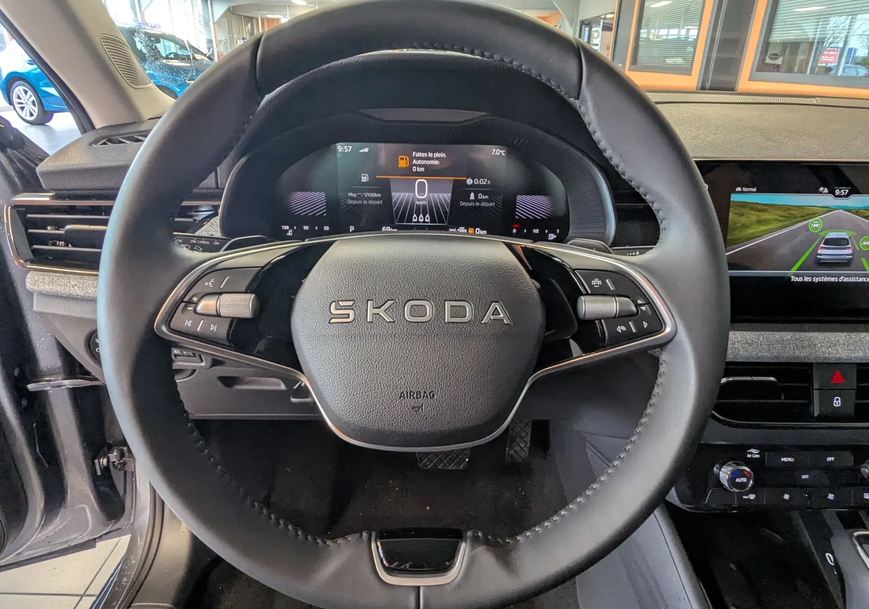 Vue centrée sur le volant cuir noir du Skoda Kamiq 2025 avec tableau de bord numérique et écran central tactile.