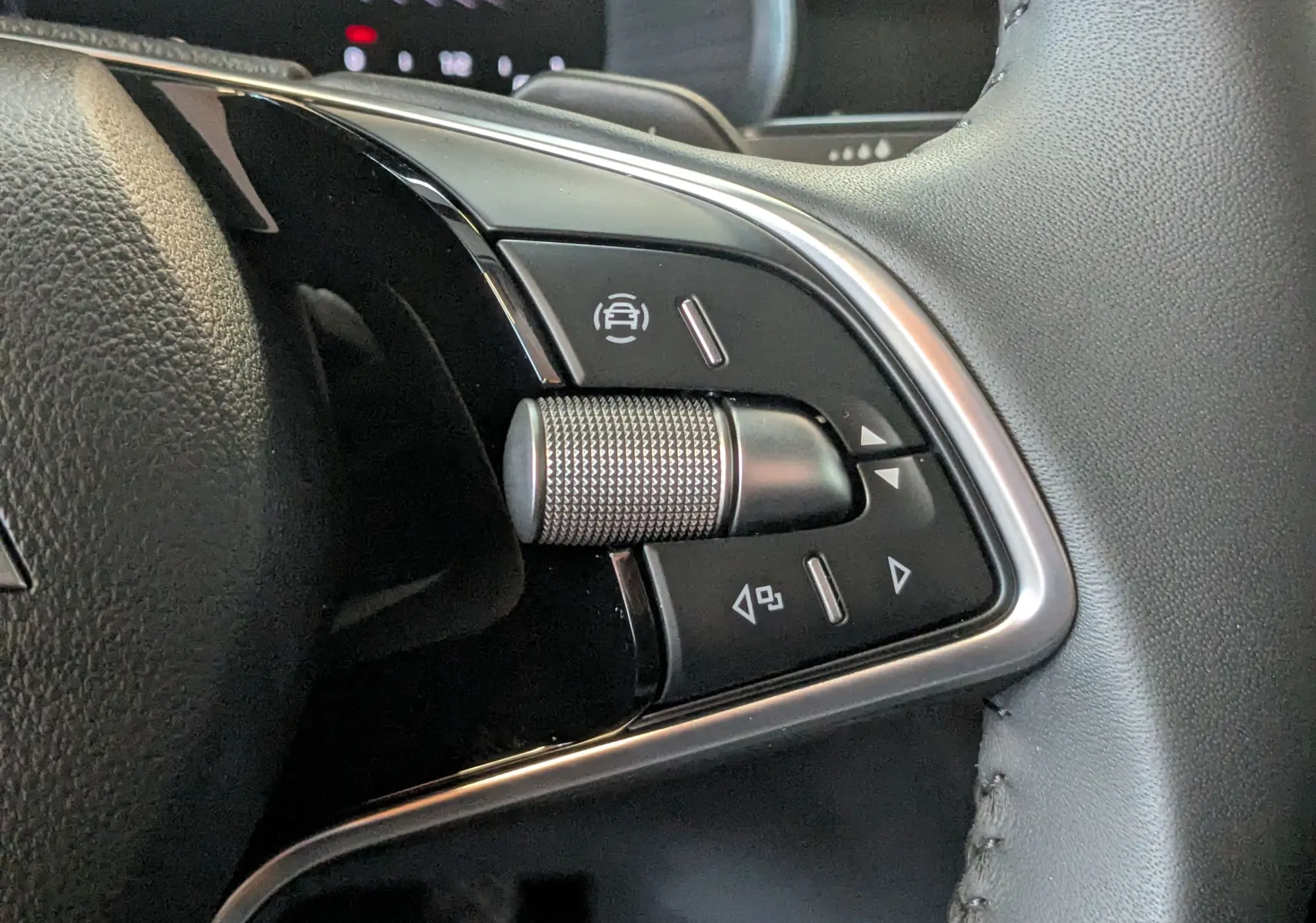 Gros plan sur les commandes à droite du volant en cuir noir du Skoda Kamiq gris graphite 2025.