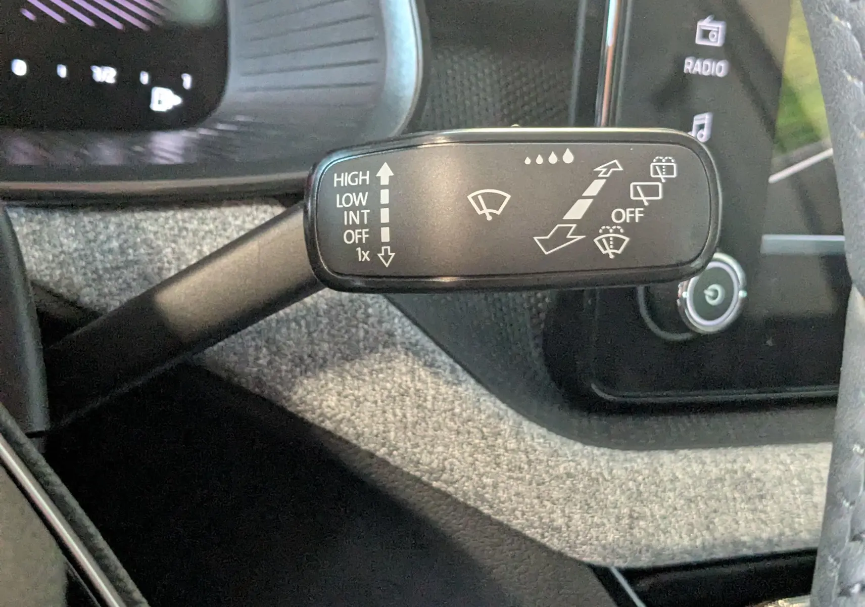 Gros plan sur la commande des essuie-glaces du Skoda Kamiq 2025, avec tableau de bord et volant partiellement visibles.