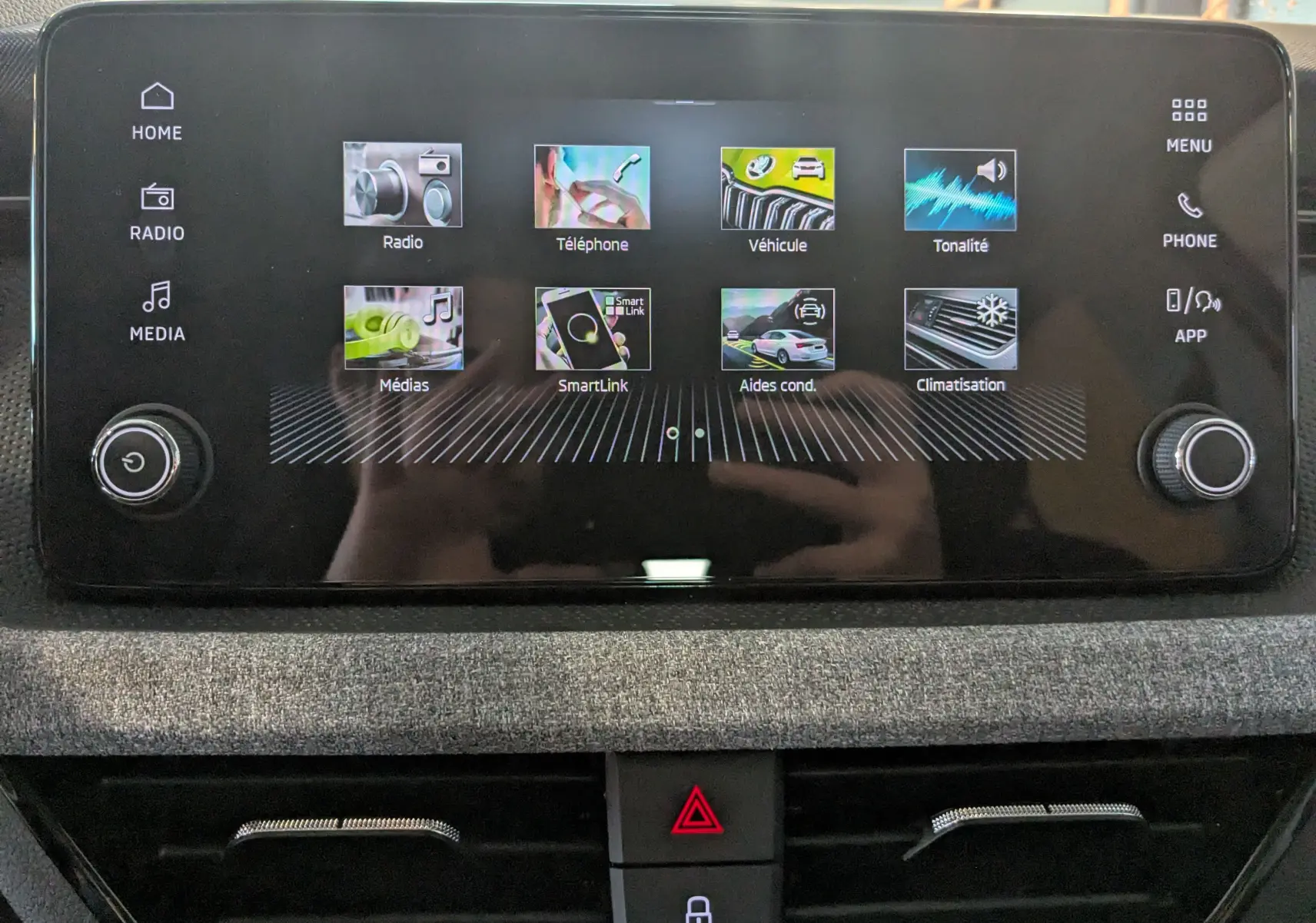 Écran tactile central du Skoda Kamiq 2025 en gris graphite, affichant les menus radio, téléphone, véhicule et climatisation.