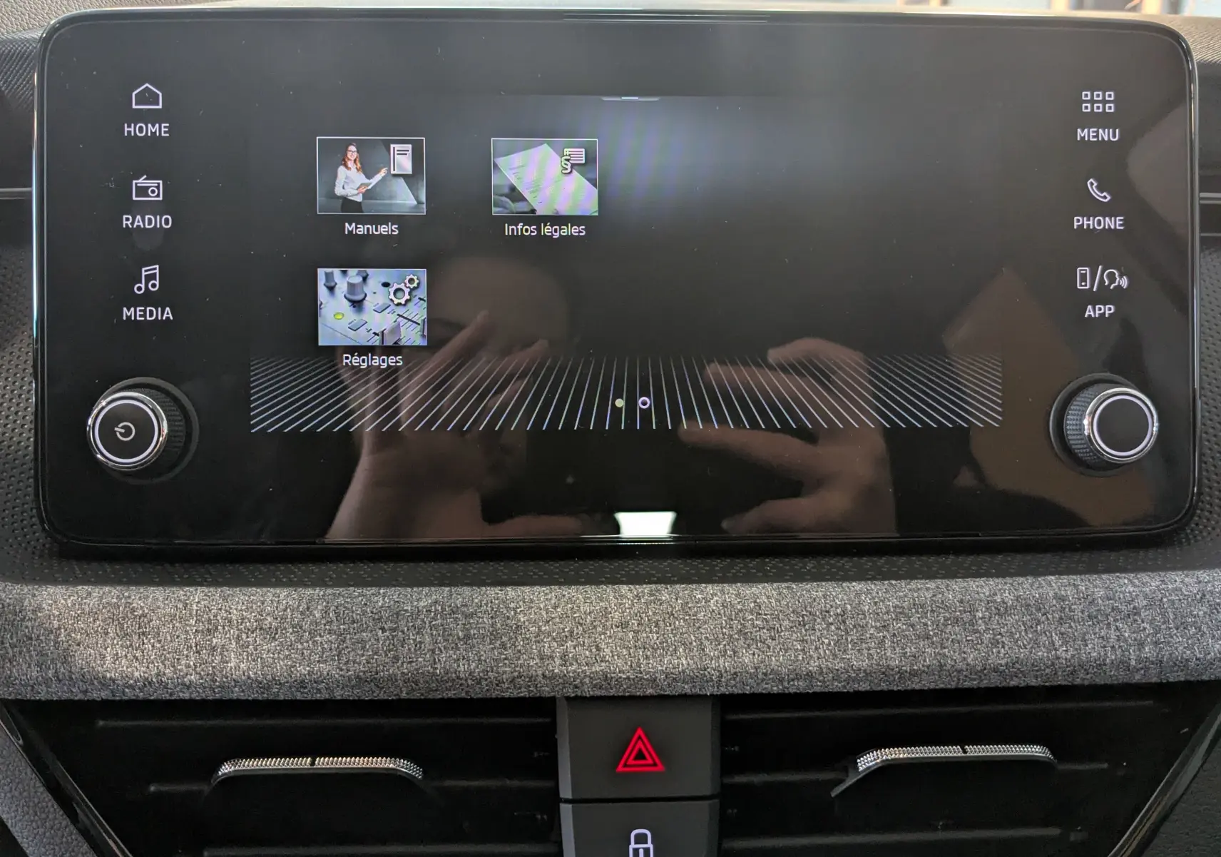 Écran tactile central du Skoda Kamiq 2025, interface affichant les menus, entouré de commandes rotatives, finition intérieure gris graphite.