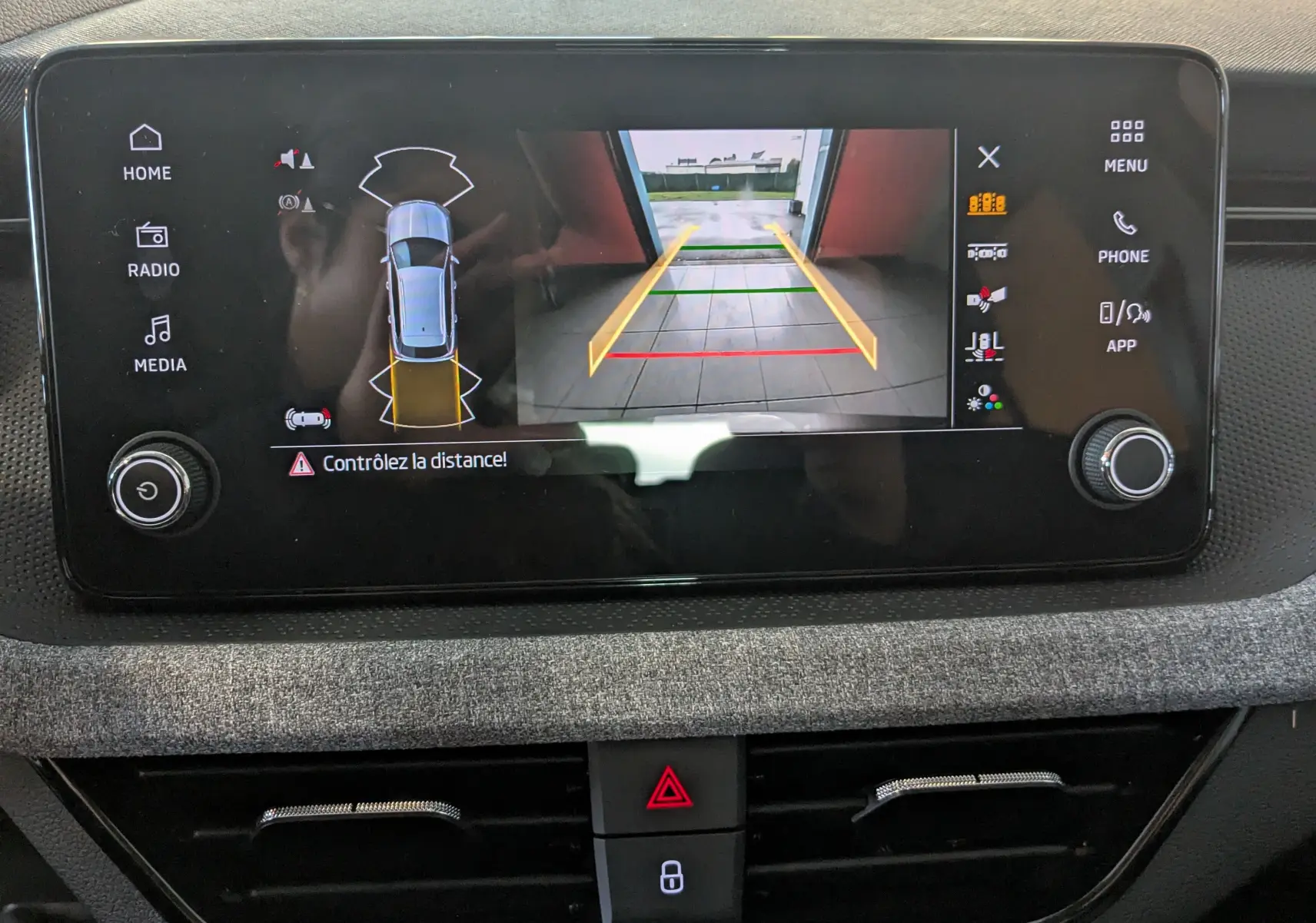 Écran central du Skoda Kamiq 2025 montrant la caméra de recul avec guidage de trajectoire en vue arrière.