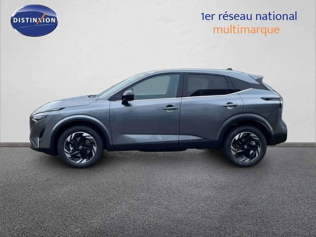 Vue de profil côté gauche du Nissan Qashqai 2025 gris squale métal avec jantes noires et toit noir contrasté.