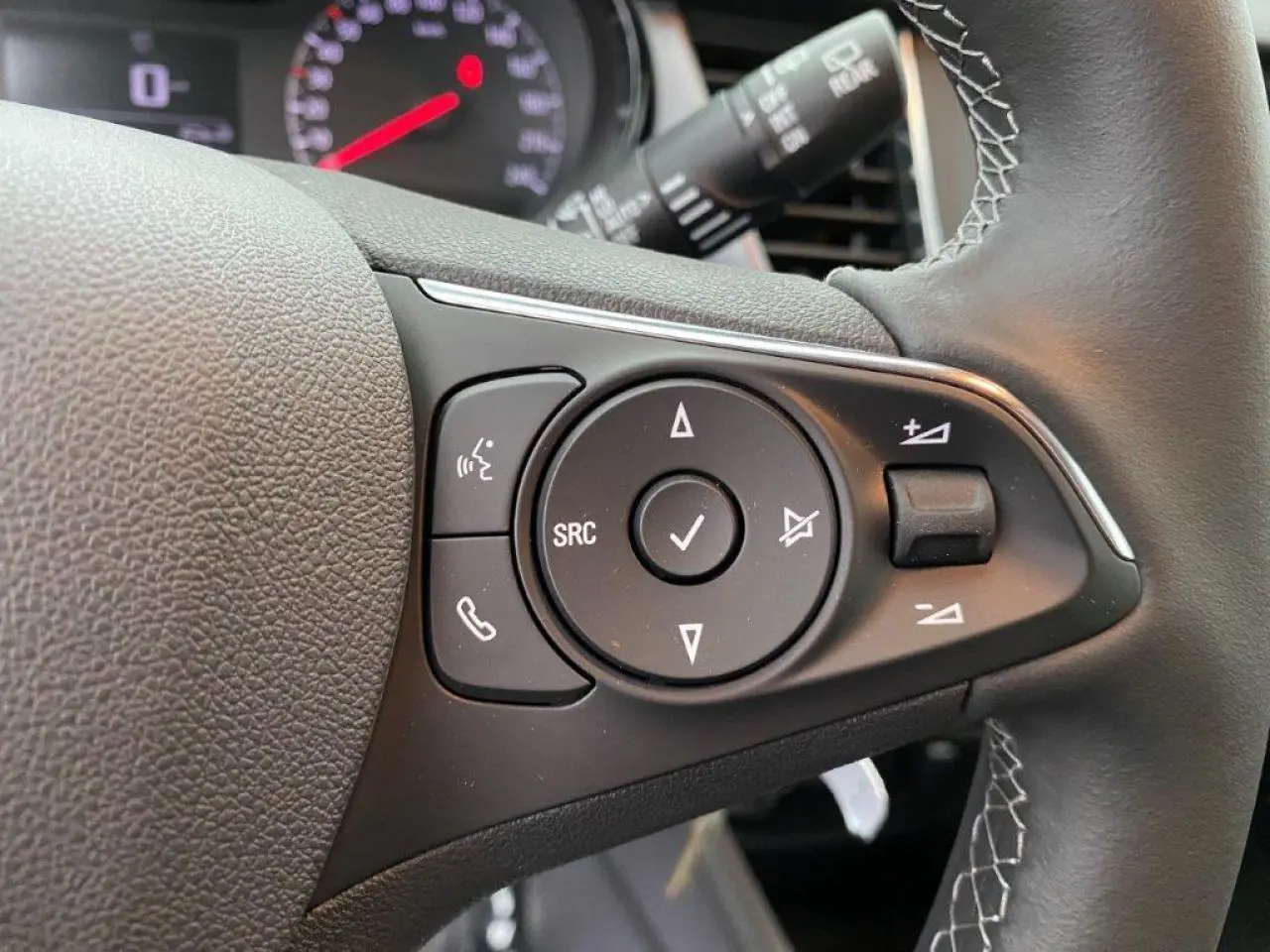 Gros plan sur les commandes du volant cuir multifonction de l’Opel Crossland 2022, version essence gris métallisé.